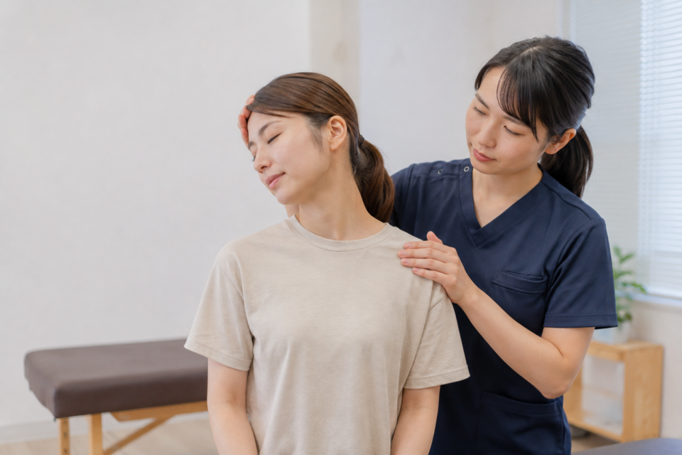 交通事故後の女性の首と肩の状態を確認する施術者