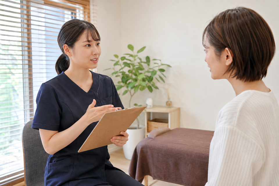交通事故後の施術計画の説明を受ける女性