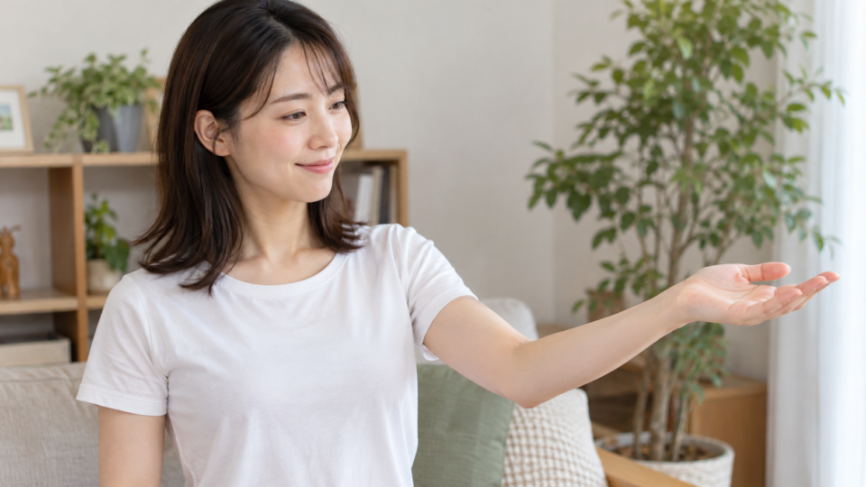 肘を軽く曲げて手のひらを上に向ける女性