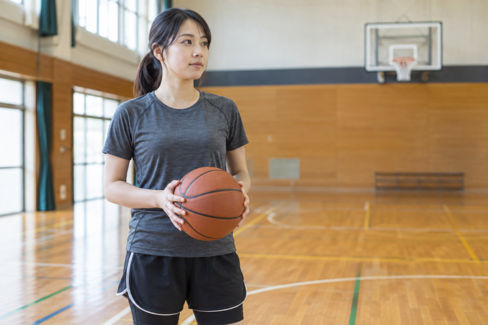 体育館でバスケットボールを持つ女性