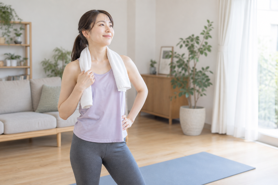 運動後にタオルを肩に掛けて立つ女性