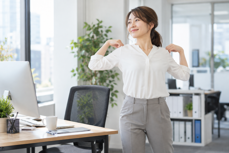 デスクの横で肩を動かして休憩する成人女性