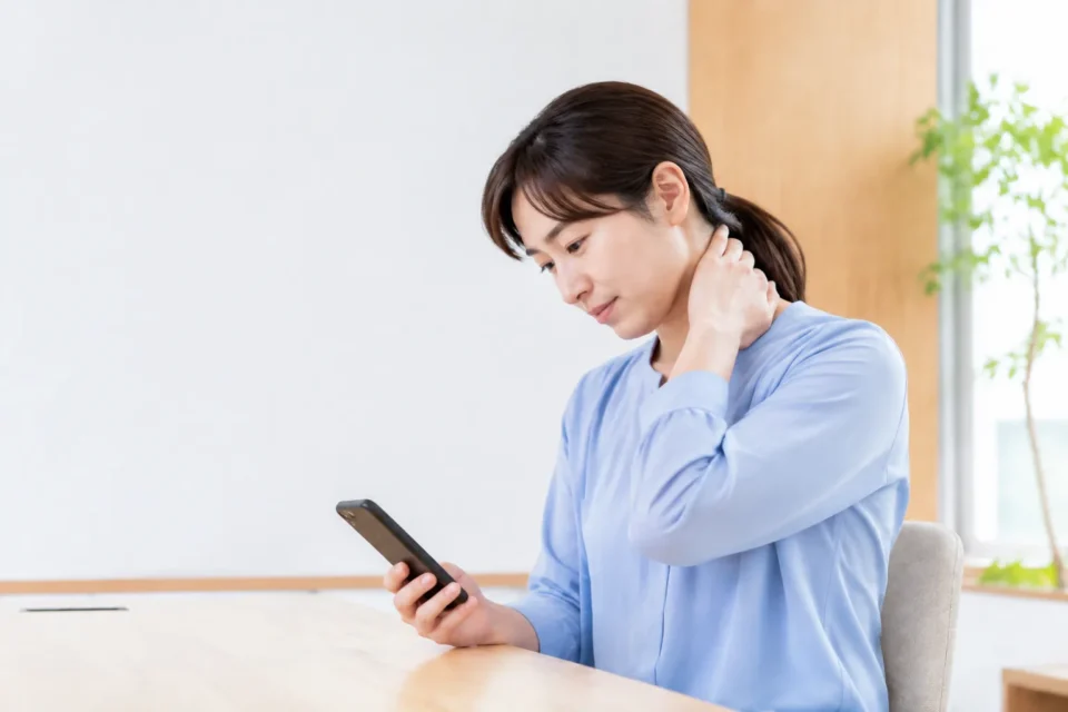 スマートフォン使用中に首のつらさを感じる女性