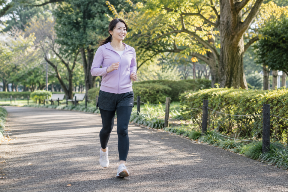公園の道を軽く走る女性