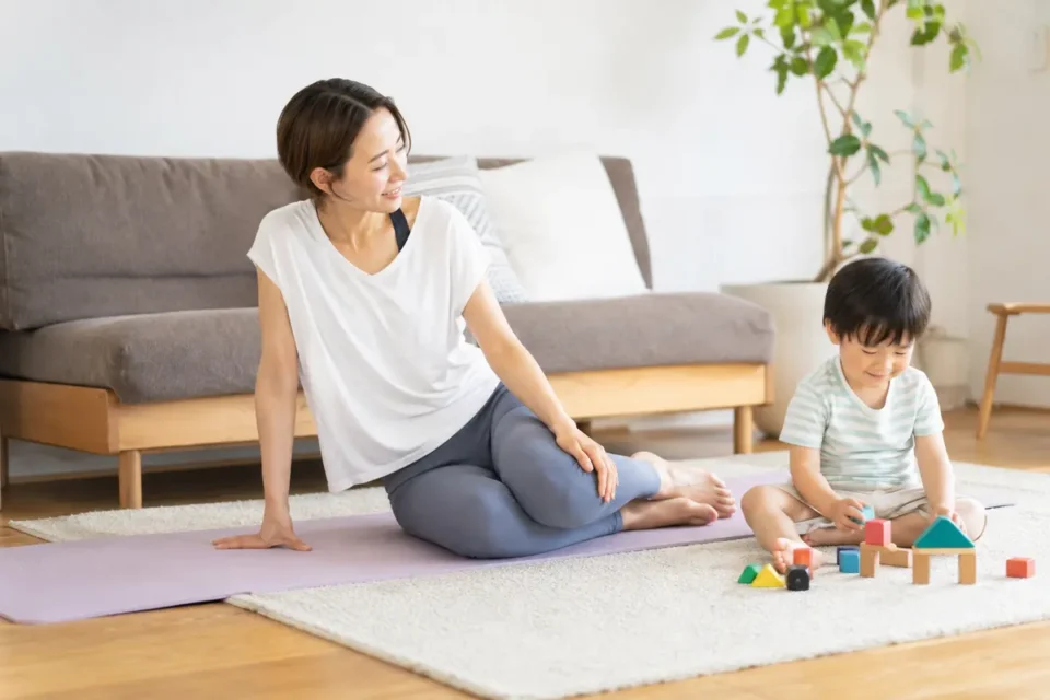 寝ながら体操を終えて子どもと過ごす産後の女性